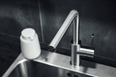 Su musluğu ve metalik lavabo modern şık mutfağa, seçici odak