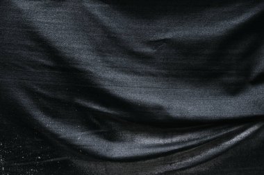 Arkaplan olarak koyu siyah buruşmuş ve buruşmuş kumaş dokusu