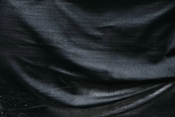 Arkaplan olarak koyu siyah buruşmuş ve buruşmuş kumaş dokusu