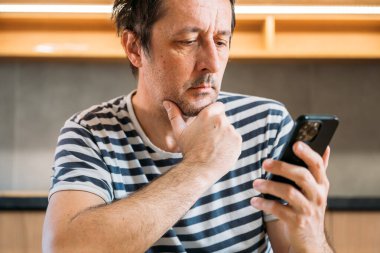 Mutfakta cep telefonu kullanan bir adam, seçici odaklanma