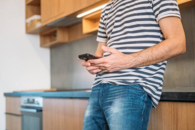 Mutfakta cep telefonu kullanan bir adam, seçici odaklanma