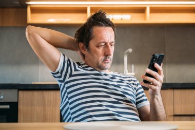 Mutfakta cep telefonu kullanan bir adam, seçici odaklanma