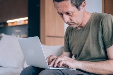 Telekomünikasyon işçisi oturma odasından bir dizüstü bilgisayarla çalışıyor, seçici odaklı.