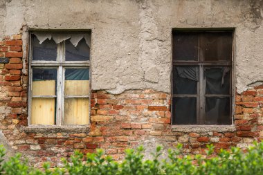 Harap olmuş bir evin kırık camlarıyla eski ahşap pencereler, yatay görüntü.