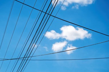 Tepedeki elektrik kablolarından görünen beyaz bulutlar, seçici odaklanma