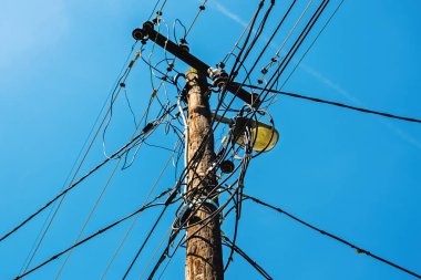 Sokak lambası ve dağınık elektrik kabloları olan eski ahşap lamba direği, seçici odaklı.