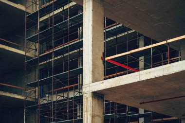 Modern şirket inşaat alanının düşük açılı görüntüsü, iskeleli beton çerçeve yapısı, seçici odaklı