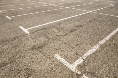 Asfalt döşemeli ve beyaz çizgili boş otoparklar, seçici odak