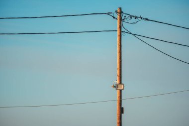 Mavi gökyüzüne karşı LED ışığı olan tahta elektrik direği, seçici odak