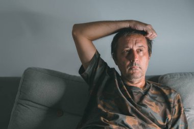 Düşük açık renkli orta yaşlı erkek portresi. Tekrar düşünmek ve karanlık odada düşünmek, seçici odaklanma.