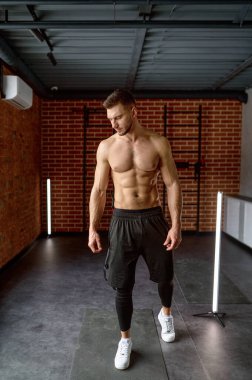 Beden eğitimi limanının iç kısımlarında atletik güçlü vücut adamının portresi. Çıplak gövdeli kaslı adam.