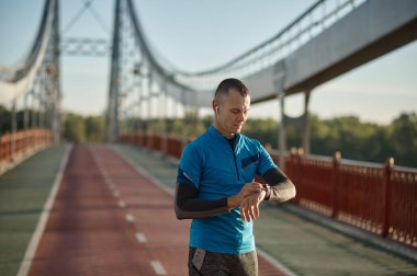 Koşucu egzersizden sonra akıllı titreşimleri kontrol ediyor. Spor ve spor, sağlıklı çalışma konsepti