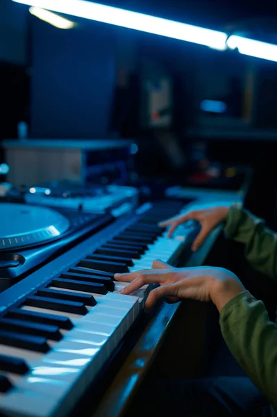 在霓虹灯录音室演奏合成器的年轻键盘手音乐家 — 图库照片