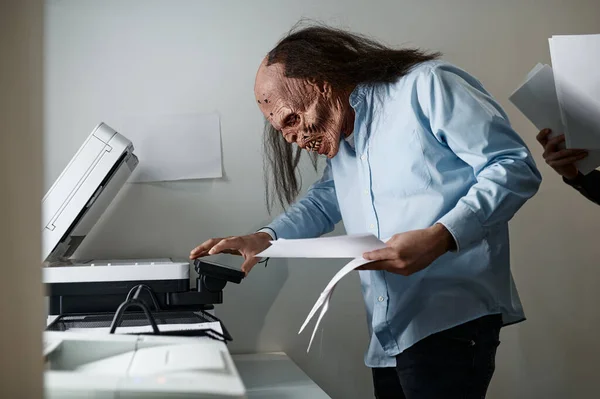 Zombie在办公室的复印机里使用打印机扫描仪复制纸质文件的穷苦工人 — 图库照片
