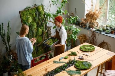 Çiçekçi ve dekoratör bitkilerden el işi yapıyor. Yaratıcı tasarımcı mesleği