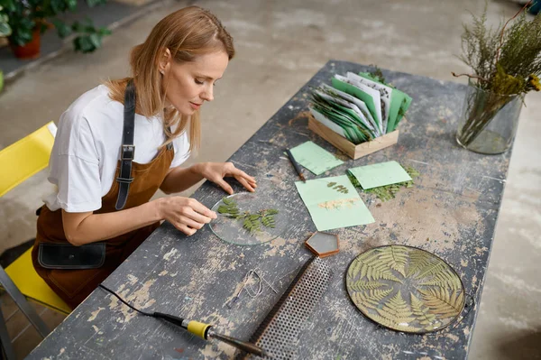 A female artist making creative floral composition at craft workspace