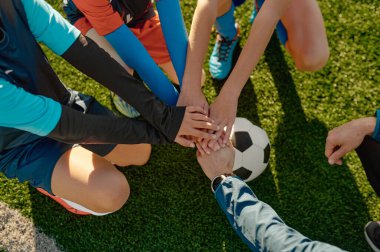 Futbol koçu topa el atmadan önce küçükler futbol takımını motive ediyor.