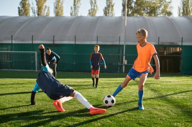 Genç çocuklar spor okulunda küçükler yarışması sırasında futbol oynuyorlar. Çocuklar için futbol turnuvasının final maçı