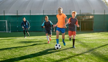 Genç çocuklar spor okulunda küçükler yarışması sırasında futbol oynuyorlar. Çocuklar için futbol turnuvasının final maçı