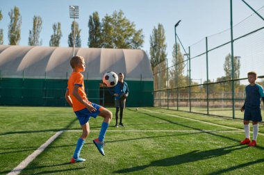 Çocuklar için antrenman kampında futbol oynayan genç çocuklar. Yaz aylarında gençler için spor turnuvası