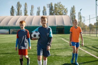 Futbol topuyla sahada takım arkadaşlarıyla duran ciddi bir genç futbolcunun portresi