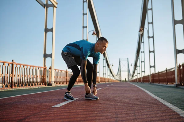 달리기용 신발에 레이스를 선수가 조깅을 준비를 도시의 다리에서 훈련받고 스턴트맨 — 스톡 사진