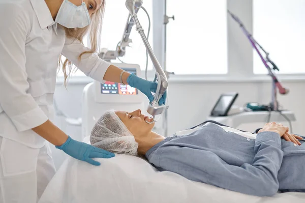 Üst Düzey Kadın Müşteri Tıbbi Kanepede Uzanıp Profesyonel Güzellik Kliniğinde — Stok fotoğraf