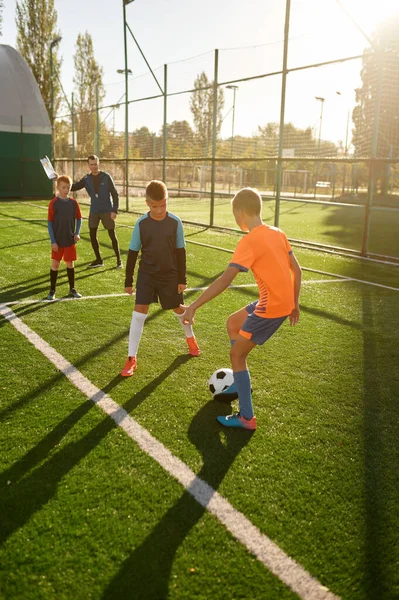 Dois jogadores de futebol fazendo exercícios de alongamento no campo.  treinamento de futebol em estádio ao ar livre, treino em equipe antes do  jogo