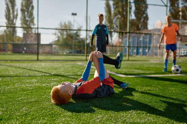 Mladý Fotbalista Zraněným Kolenem Ležícím Hřišti Během Zápasu Zraněný Kluk — Stock fotografie