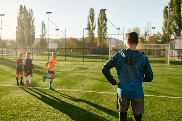 Dzieciaki Ćwiczące Piłkę Nożną Trawie Pod Kontrolą Trenera Footballu Grupa — Zdjęcie stockowe