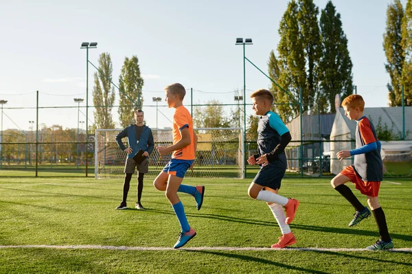 Dzieciaki Ćwiczące Piłkę Nożną Trawie Pod Kontrolą Trenera Footballu Grupa — Zdjęcie stockowe