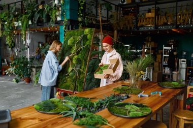 Çiçekçi dükkanında ev tasarımı için iki tasarımcı çalışıyor.