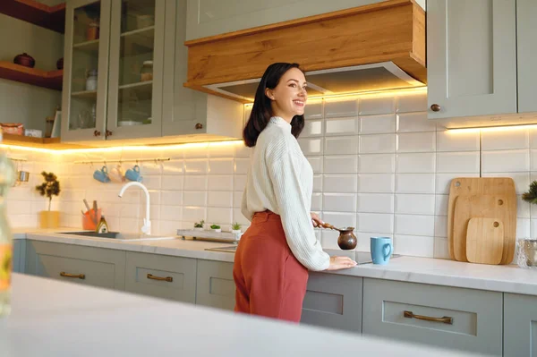 幸せな若いです女性調理コーヒーでセブカップのために朝食上のホームキッチン — ストック写真