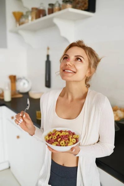 幸せなスリムな若い女性の肖像キッチンに立って朝食のための食事おいしい食べ物を楽しんで — ストック写真