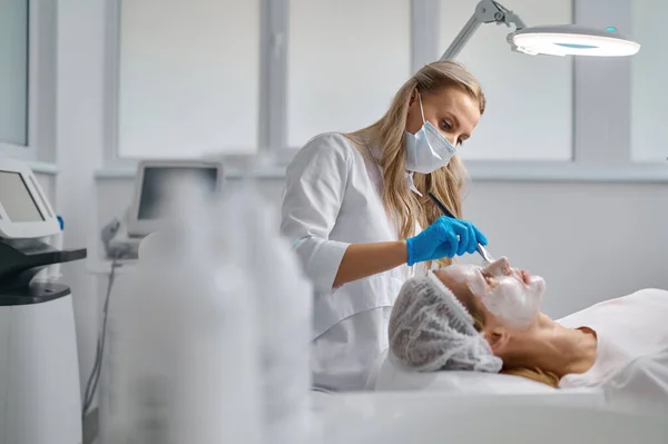Beautician Applying Clay Face Mask Woman Face Side View Rejuvenation — Foto de Stock