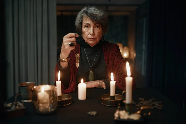 Portrait Serious Confident Fortune Teller Holding Crystal Pendant Candle Light — Stock fotografie