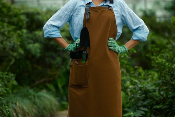 女园丁穿着工作服 口袋里夹着花园用的小铲子和耙具 园艺和耕作业余爱好概念 — 图库照片