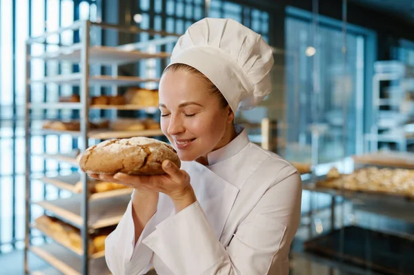 Jonge Vrouwelijke Bakker Ruiken Smakelijk Vers Brood Moderne Commerciële Bakkerij — Stockfoto