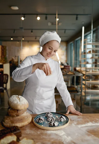 Een Vrouwelijke Bakker Chef Kok Besprenkelt Vers Gebakken Havermoutkoekjes Met — Stockfoto