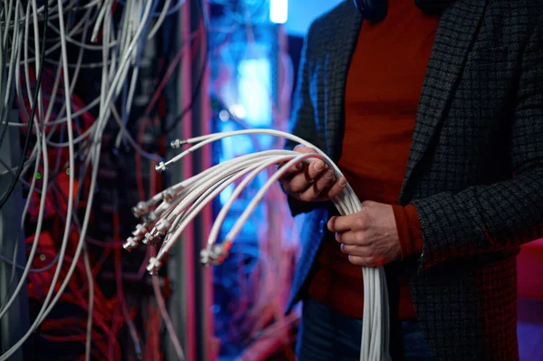 ネットワークサーバールームで作業している間 手にケーブルの束を持つItマンのクローズアップビュー 採掘暗号通貨のエンジニア設定ファーム — ストック写真
