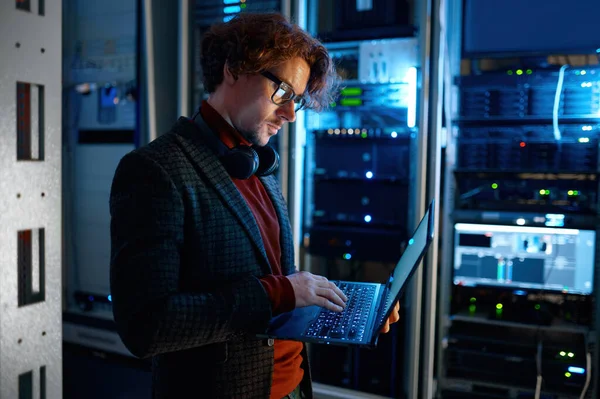 기술자는 노트북 컴퓨터를 사용하여 바이탈을 어두운 네트워크 룸에서 일하는 에이전트 — 스톡 사진