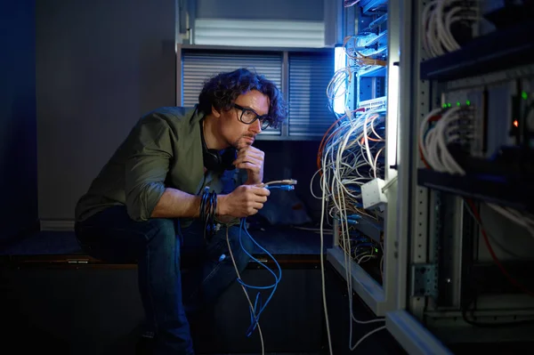 네트워크 엔지니어는 데이터 센터의 작업중 케이블을 젊은이는 장비에 연결하기 최적의 — 스톡 사진