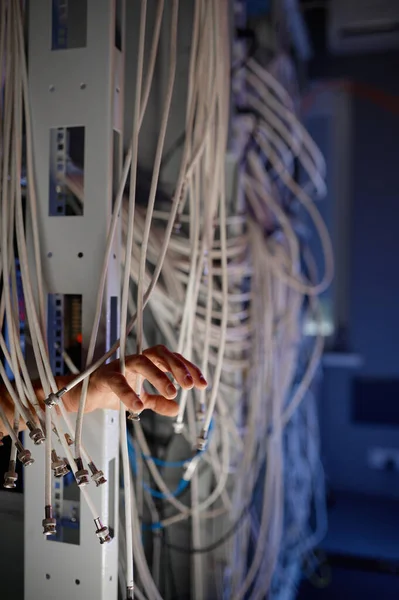手缠在电线里 现代数据中心概念服务器机房中的许多电缆工作及与Internet连接有关的问题 — 图库照片