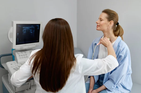 甲状腺の超音波やリンパ節の閉鎖を行う女性医師 現代の診療所での完全な健康診断 — ストック写真