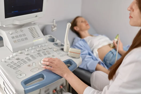 現代の出生前クリニックオフィスで妊婦に胎児の超音波を行う選択的焦点医師 — ストック写真