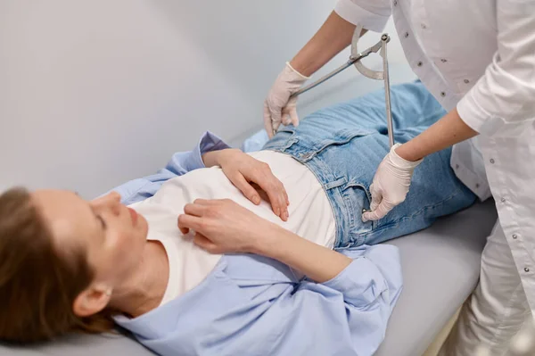産後医療センターでの検査中に女性患者の股関節量を測定する婦人科医 — ストック写真