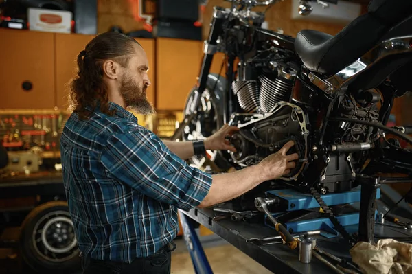 ガレージの工房で働いてるオートバイのエンジンを修理する機械工 彼の鉄の馬を修理する勇敢な男性バイカー — ストック写真