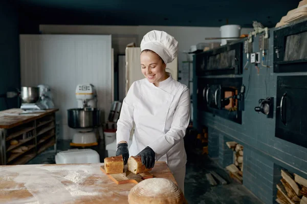 Mulher Sorrindo Jovem Padeiro Chef Segurando Faca Cortando Pão Fresco — Fotografia de Stock