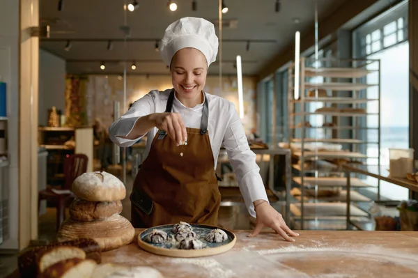 焼きたてのオートミールクッキーをシリアルで振りかける女性のパン職人 パン屋と菓子のコンセプト — ストック写真