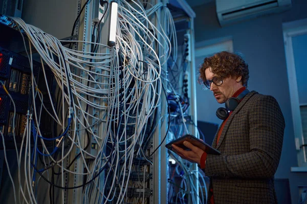 男性It技术专家在服务器室进行诊断 人工工程师用计算机设备在架子附近安装电缆 — 图库照片